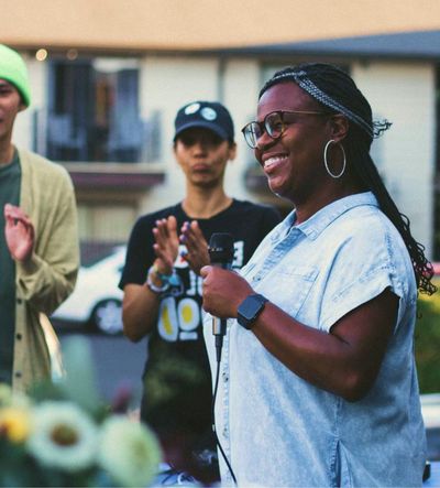 Woman holding microphone speaking at UCAN event in Denver, CO