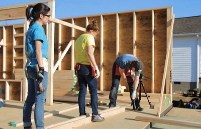 UCAN general contractor volunteer providing two young female adults training on home construction